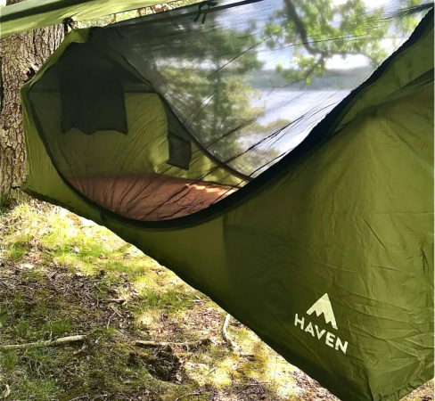 A tent hanging above the ground in the forest