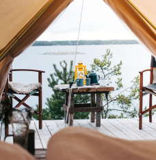 A glamping tent with a lake outisde